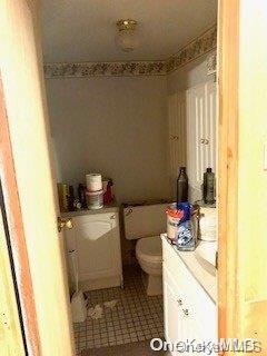 bathroom featuring tile patterned flooring, vanity, and toilet