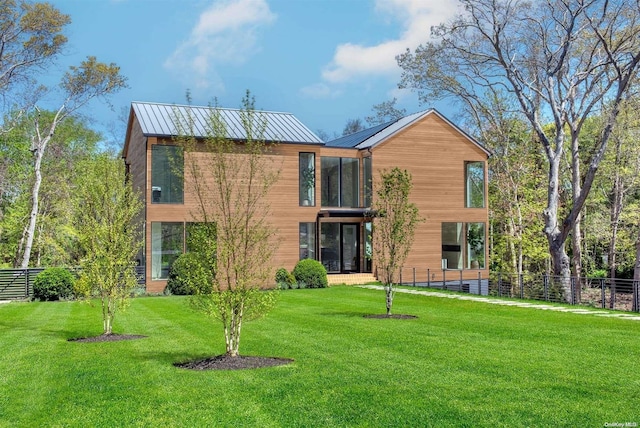 1739 Millstone Rd, Sag Harbor, NY 11963 - rear view of house with a lawn, metal roof, a standing seam roof, and fence