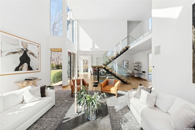 1739 Millstone Rd, Sag Harbor, NY 11963 - living area featuring stairway, visible vents, a towering ceiling, and wood finished floors