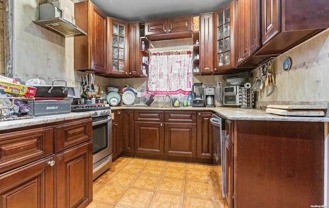 kitchen with decorative backsplash, light stone counters, extractor fan, and appliances with stainless steel finishes