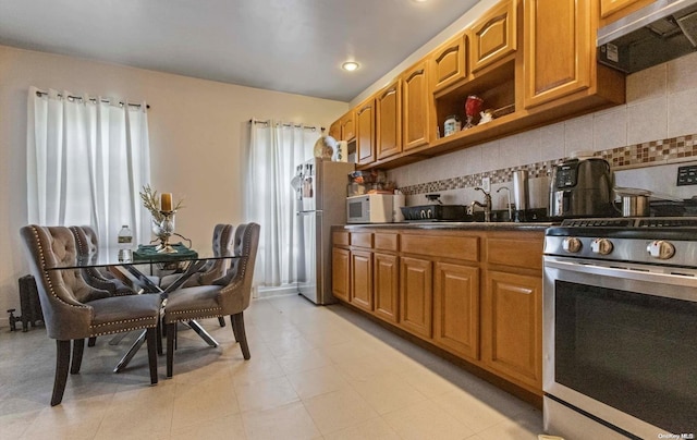 kitchen with decorative backsplash, sink, and stainless steel appliances