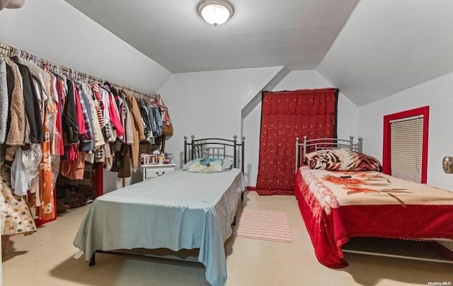 bedroom with light colored carpet and lofted ceiling