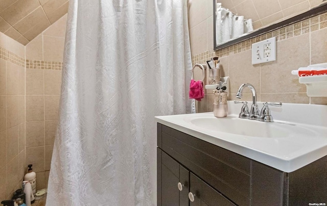 bathroom featuring vanity and tile walls