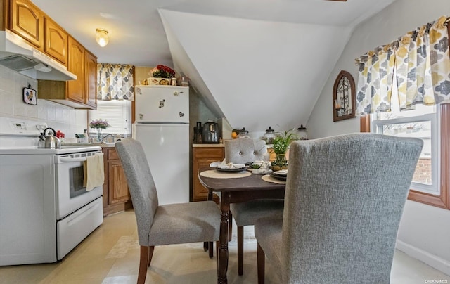 kitchen with vaulted ceiling, tasteful backsplash, and white appliances