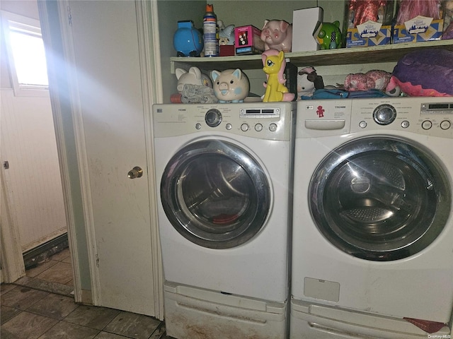 clothes washing area with dark tile patterned floors and separate washer and dryer