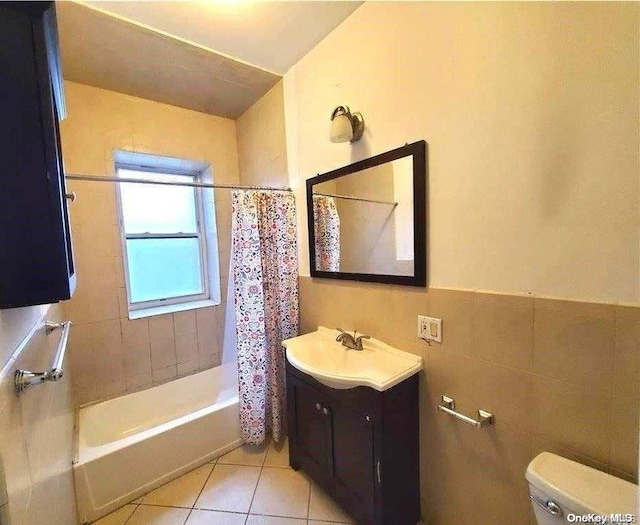 full bathroom featuring vanity, tile patterned floors, shower / bath combination with curtain, toilet, and tile walls