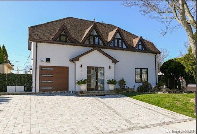 view of front of property with a garage and a front lawn