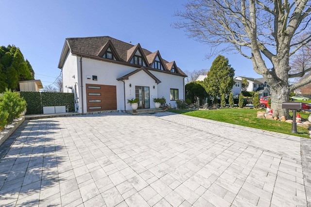 view of front facade with a front yard, french doors, and a garage