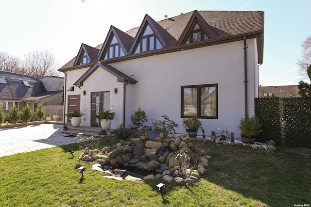 view of front facade with a patio area, a front yard, and french doors