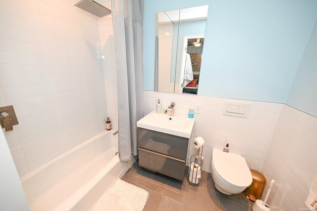 full bathroom with tile patterned flooring, shower / bath combo, tile walls, and toilet