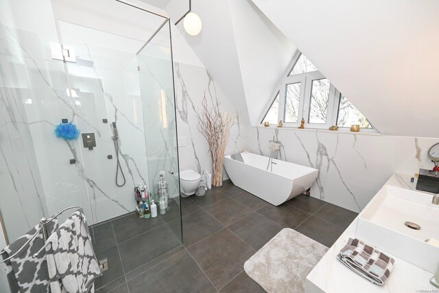 full bathroom featuring tile patterned floors, separate shower and tub, vaulted ceiling, toilet, and tile walls