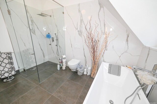 bathroom featuring tile patterned floors, toilet, and tile walls