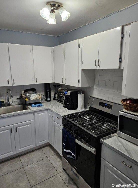 kitchen with backsplash, sink, white cabinetry, and stainless steel appliances