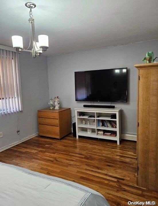 bedroom featuring a chandelier, dark hardwood / wood-style flooring, and a baseboard radiator