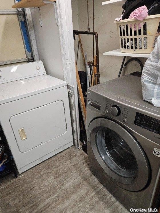 washroom featuring washing machine and dryer and wood-type flooring