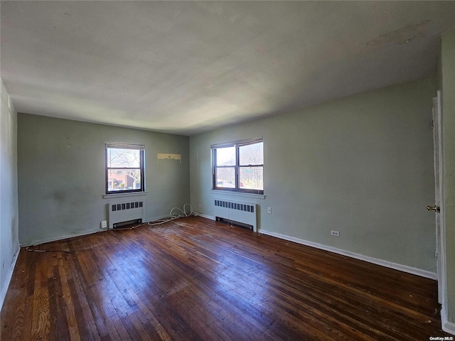 empty room featuring dark wood-type flooring and radiator