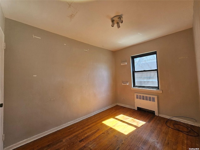 unfurnished room with wood-type flooring and radiator