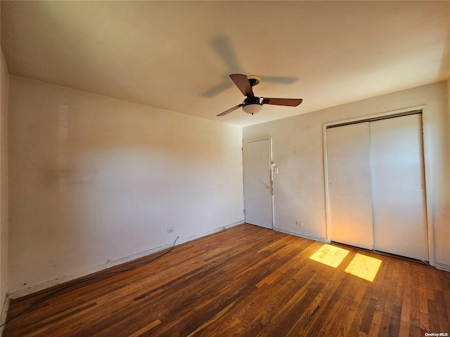 unfurnished bedroom featuring ceiling fan, a closet, and dark hardwood / wood-style floors