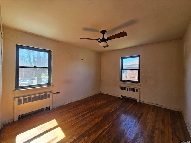 unfurnished room featuring radiator heating unit, ceiling fan, and dark wood-type flooring