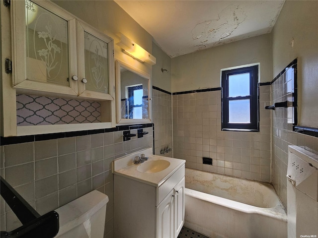 bathroom featuring vanity, toilet, tile walls, and a tub