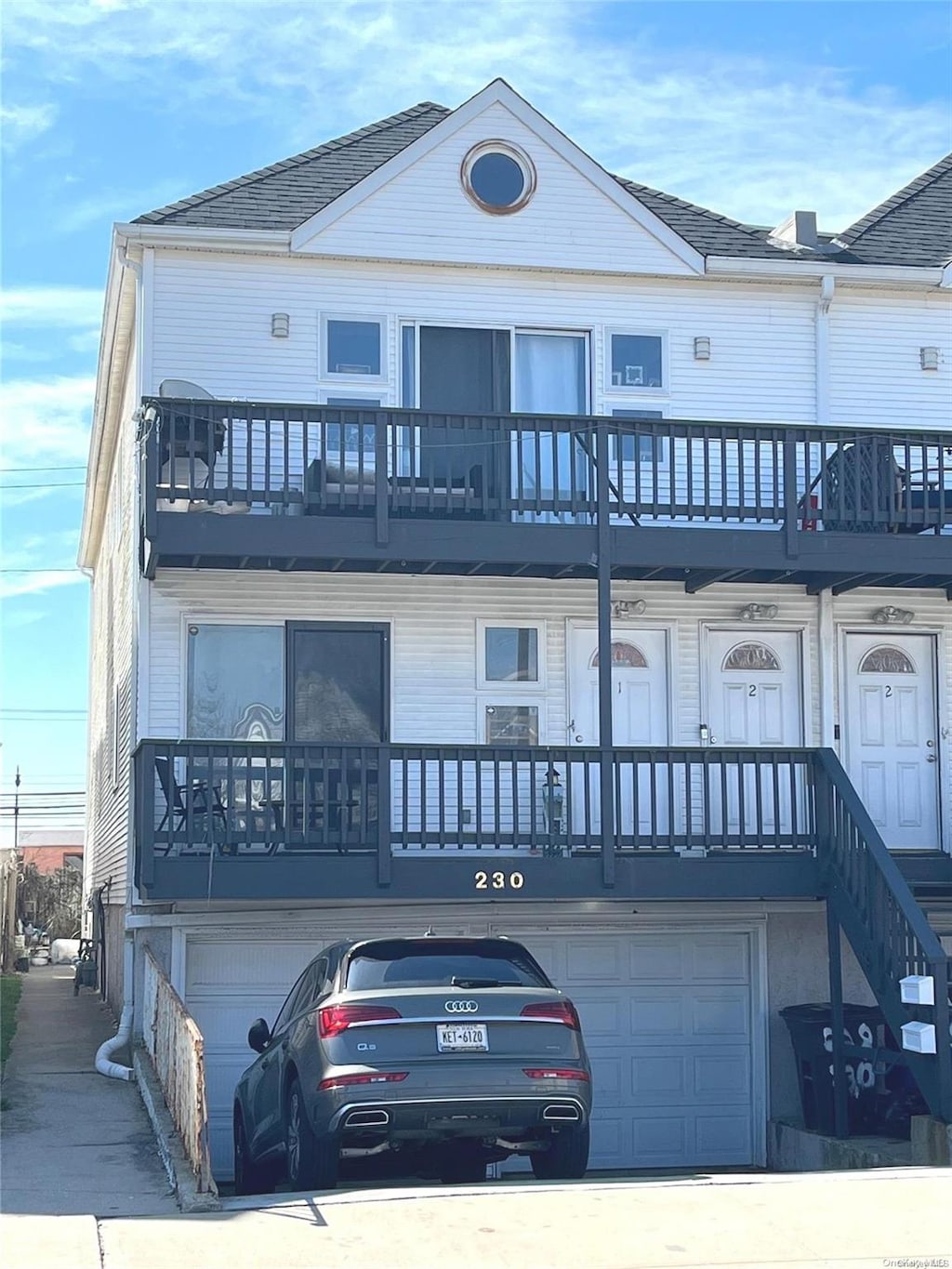 view of front of property featuring a balcony and a garage