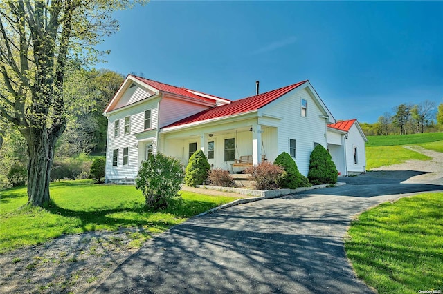 view of property exterior featuring a porch and a yard