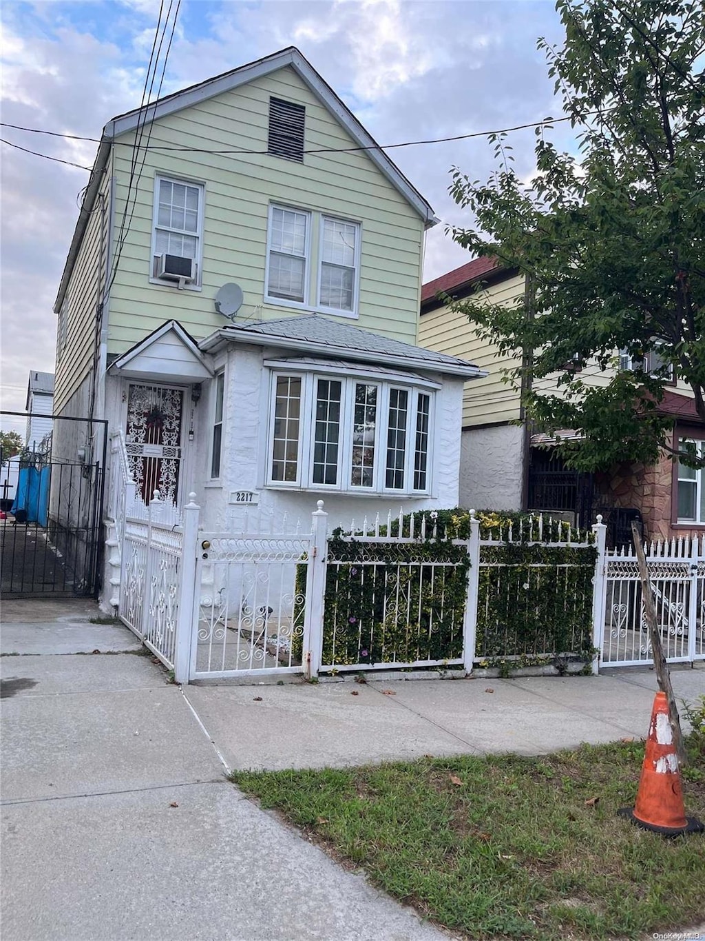 2217 Homer Ave, Bronx, NY 10473 - view of front facade with a gate, a fenced front yard, and cooling unit