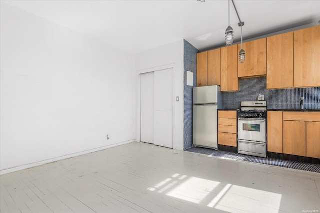 kitchen with sink, hanging light fixtures, light wood-type flooring, appliances with stainless steel finishes, and tasteful backsplash