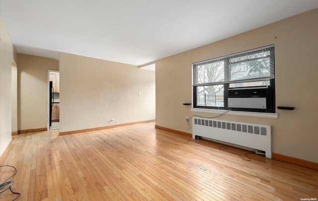 unfurnished living room with radiator and light hardwood / wood-style flooring