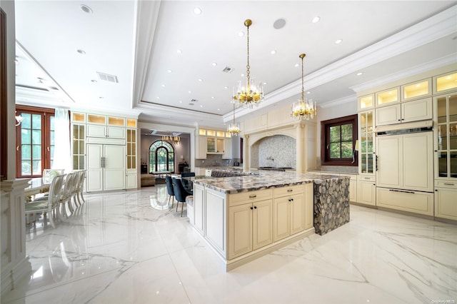 kitchen with decorative backsplash, pendant lighting, cream cabinetry, and plenty of natural light