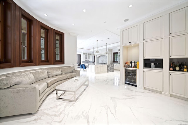 living room featuring bar area, beverage cooler, and ornamental molding