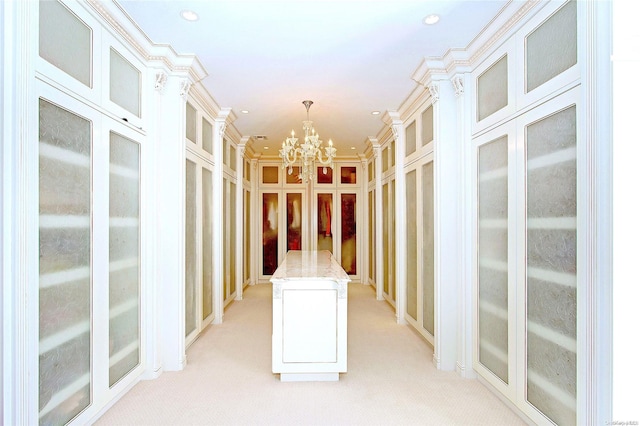 spacious closet with light colored carpet and an inviting chandelier