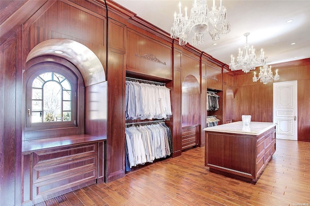 walk in closet featuring dark hardwood / wood-style flooring and a notable chandelier