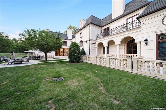 view of yard with a balcony and a patio