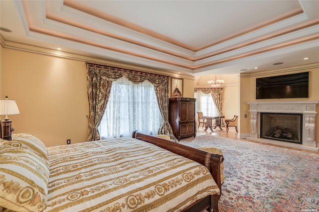 bedroom featuring a tray ceiling, multiple windows, and crown molding