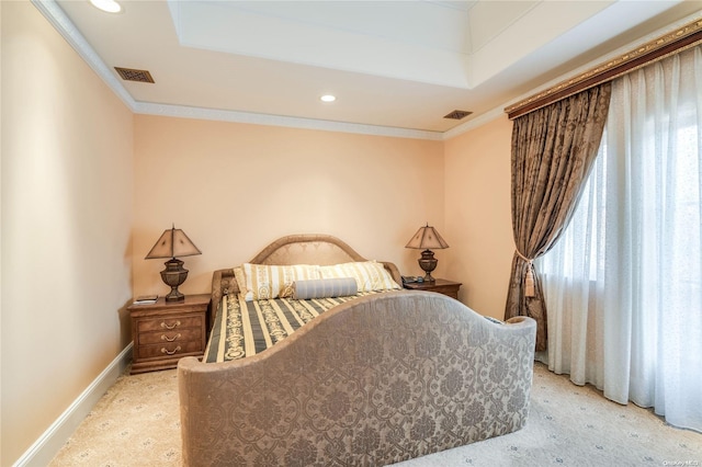 carpeted bedroom featuring a tray ceiling and ornamental molding