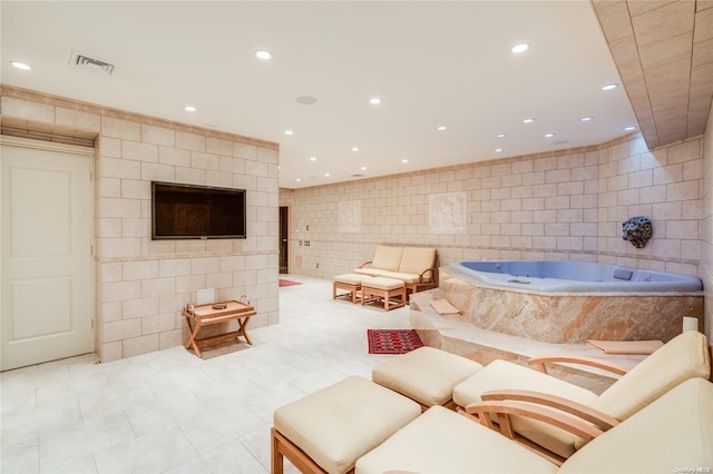 living room featuring light tile patterned flooring and tile walls