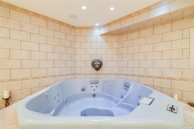 bathroom featuring a relaxing tiled tub and tile walls