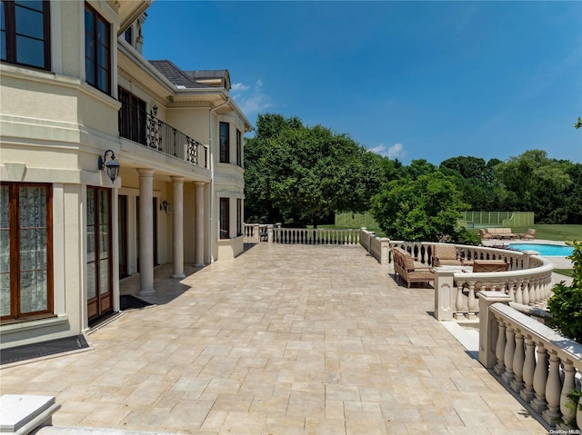 view of patio / terrace with a balcony and an outdoor fire pit