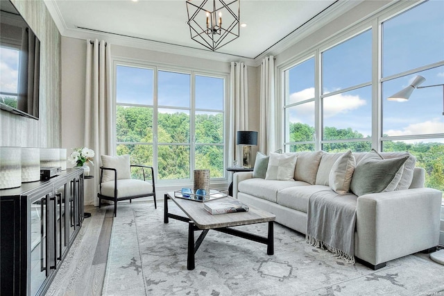 living room with light wood-type flooring, a wealth of natural light, and an inviting chandelier