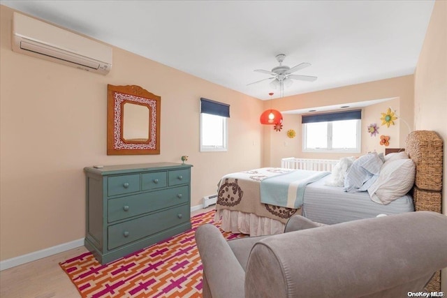 bedroom with ceiling fan, a baseboard radiator, light wood-type flooring, and an AC wall unit