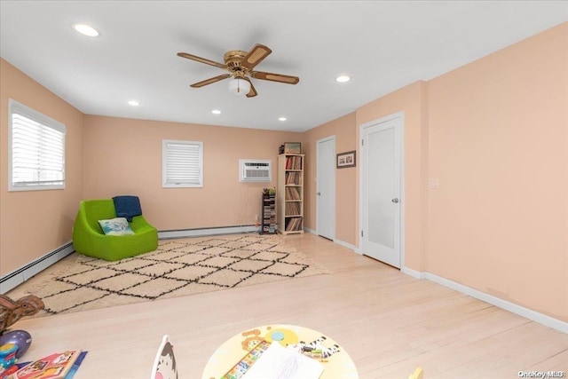 unfurnished room featuring ceiling fan, a wall mounted air conditioner, light hardwood / wood-style floors, and a baseboard heating unit