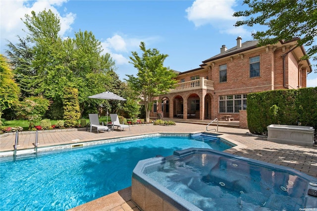 view of swimming pool with an in ground hot tub and a patio area