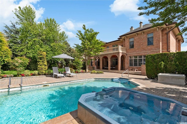 view of pool with an in ground hot tub and a patio