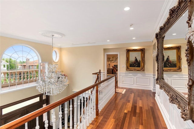 hall with crown molding, dark hardwood / wood-style flooring, and a chandelier