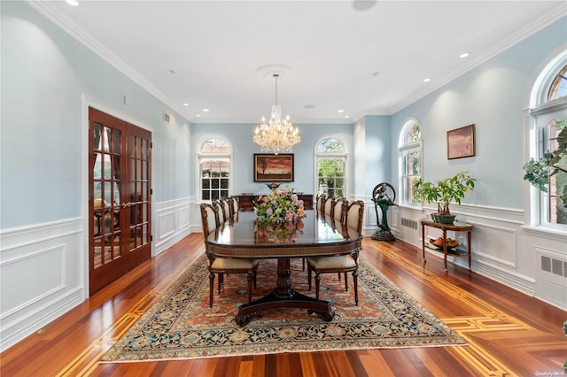 dining space with a chandelier, hardwood / wood-style flooring, radiator, and ornamental molding