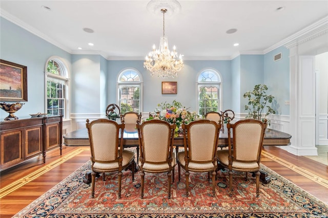 dining space with plenty of natural light, ornamental molding, and light hardwood / wood-style flooring