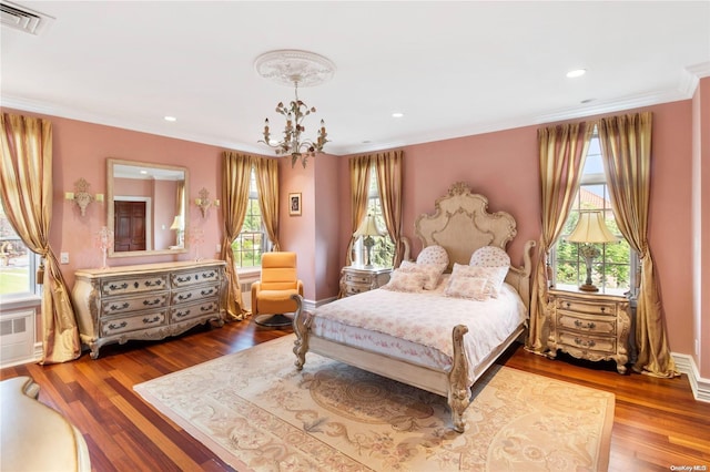 bedroom featuring hardwood / wood-style flooring, multiple windows, and ornamental molding