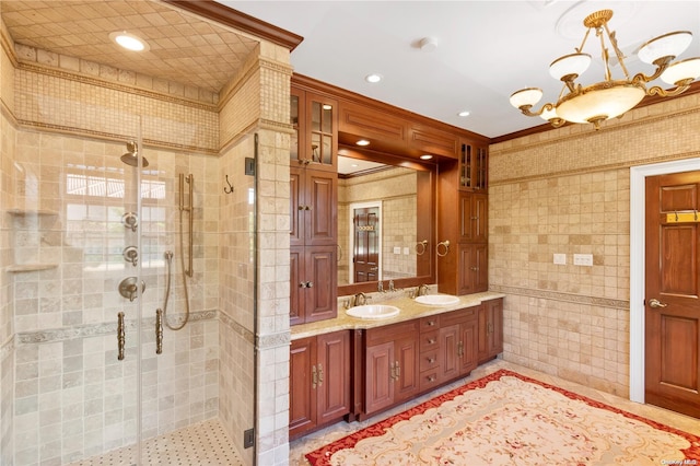 bathroom featuring a shower with door, vanity, tile walls, and ornamental molding