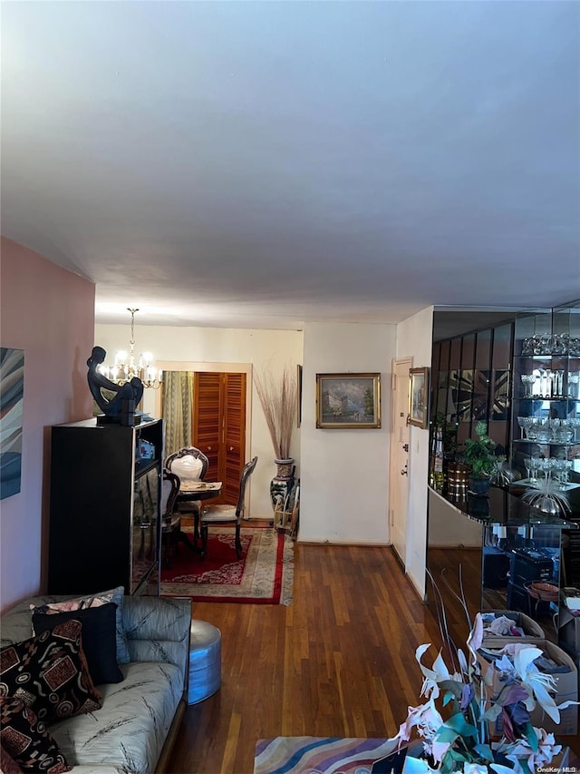 living room with dark hardwood / wood-style floors and a notable chandelier